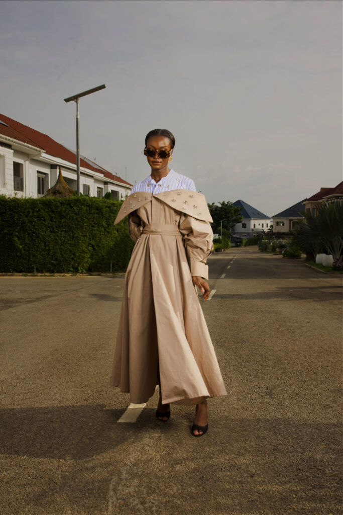 A model wearing Amnas’s embellished beige trench coat outdoors
